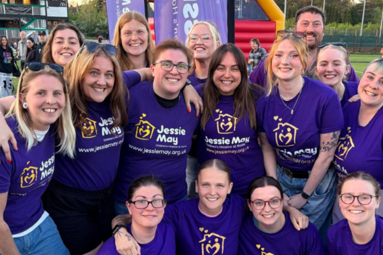 The Aretians Ladies team in purple shirts, they are lined up facing the camera and smiling.