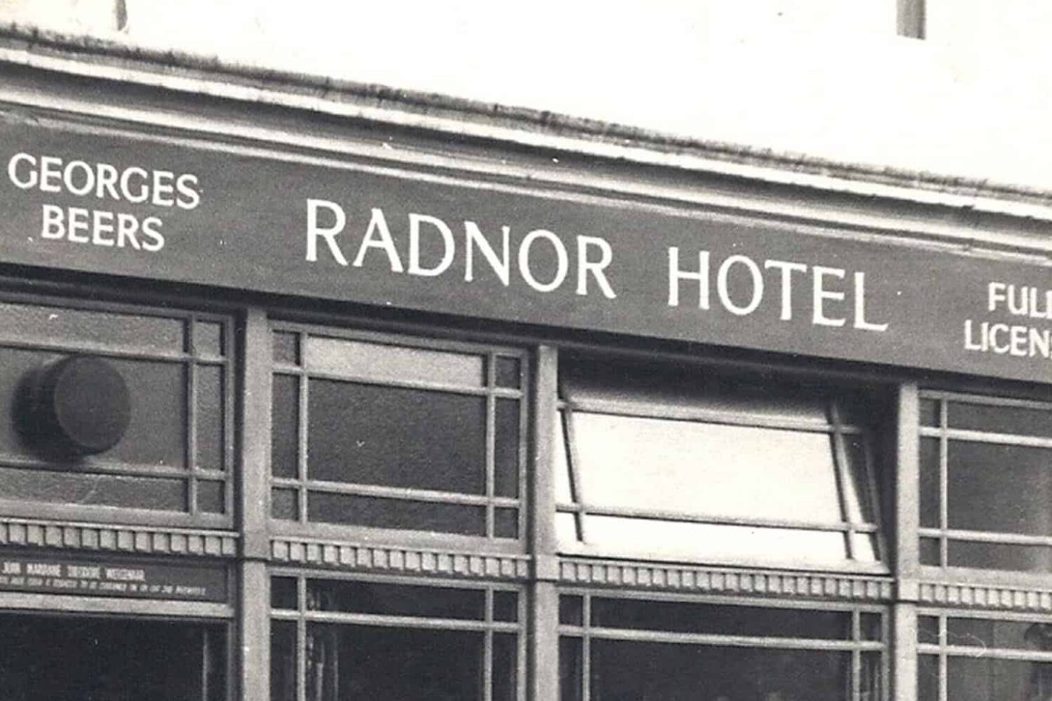 An image of a building in black and white, the sign on the building reads 