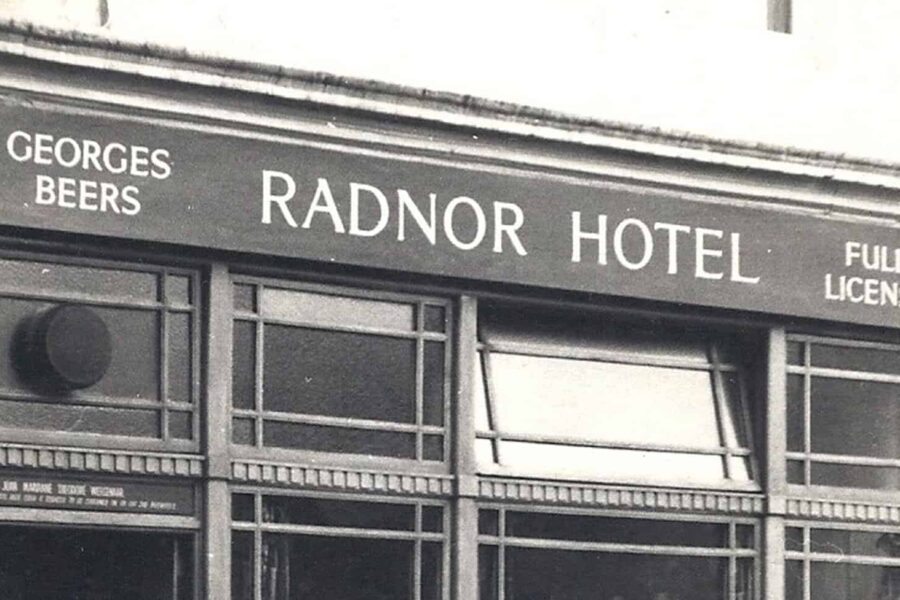 An image of a building in black and white, the sign on the building reads 