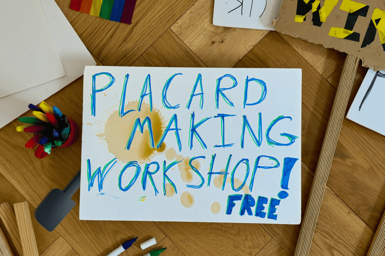 scattered art tools on the floor and banners with one reading Placard Marking Workshop! Free